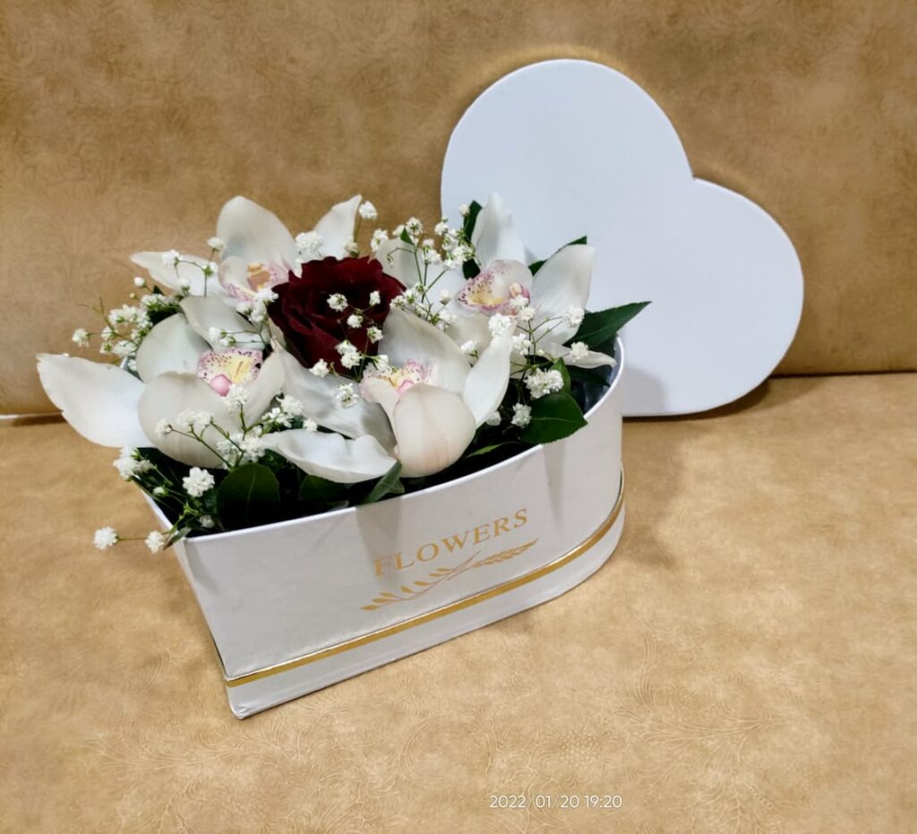 Ανθοσύνθεση σε λευκή καρδιά με ορχιδέες