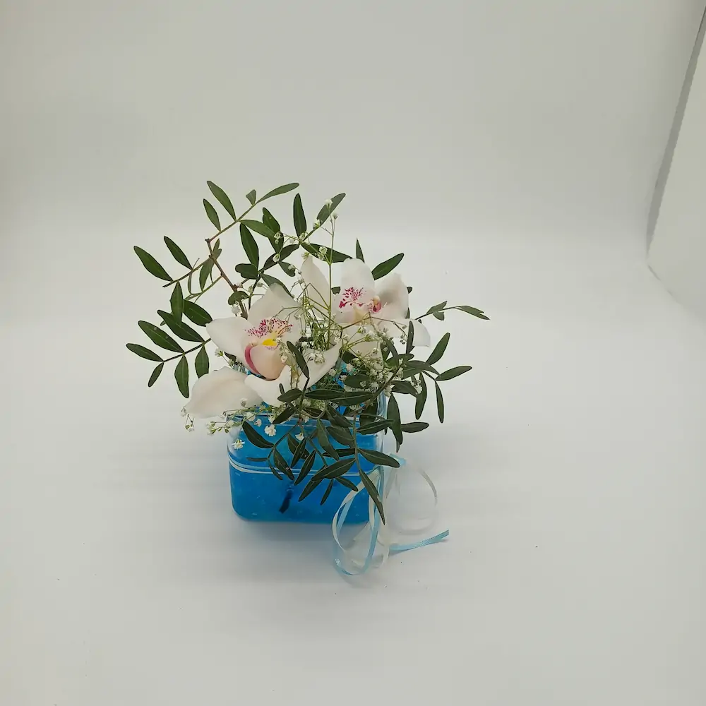 Ανθοσύνθεση με 2 ορχιδέες σε γυάλινο κύβο με γαλάζιο τζελ