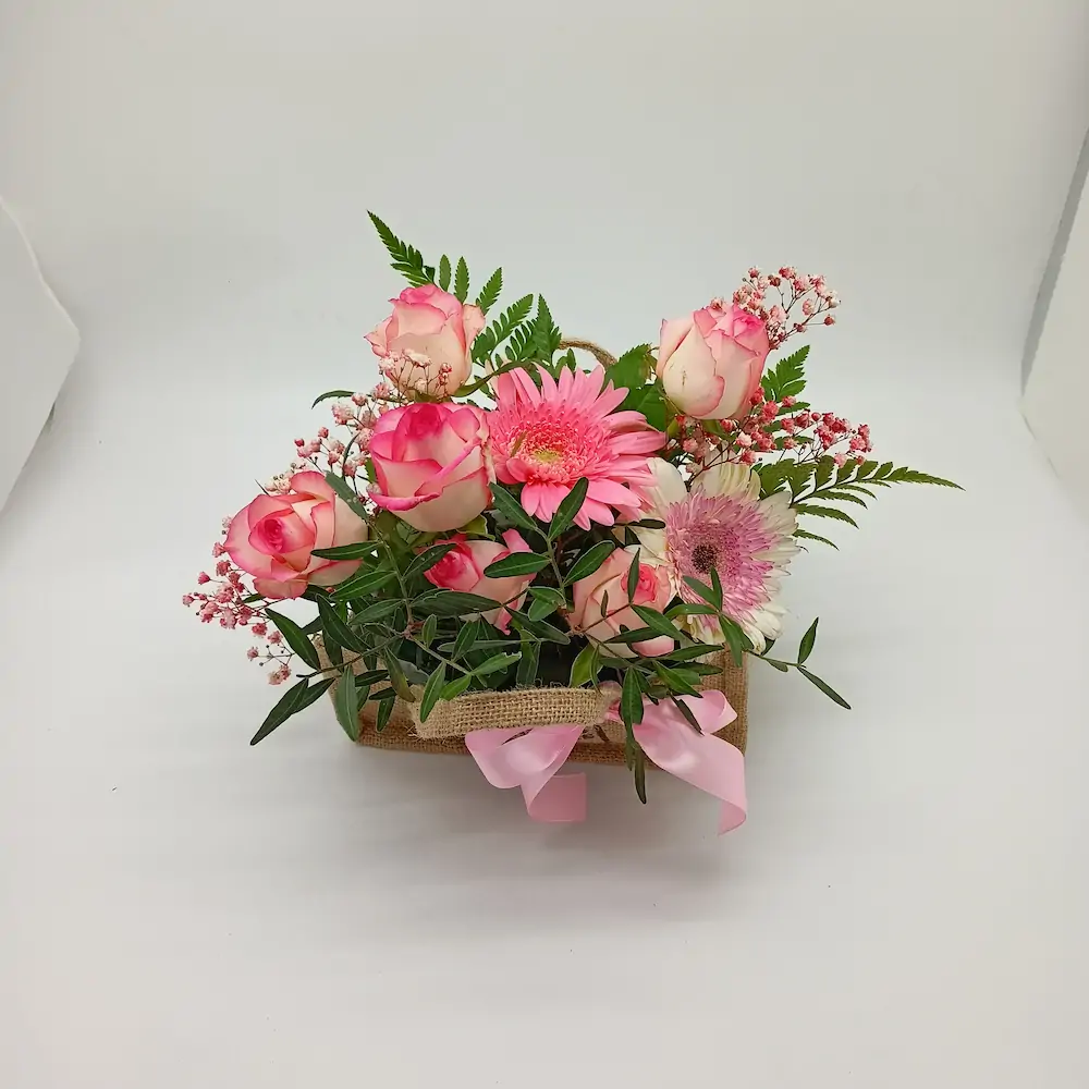 Ανθοσύνθεση με τριαντάφυλλα και ζέρμπερες σε τσαντάκι από λινάτσα